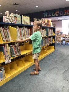 ohoopee library young patron selecting a book from the shelf