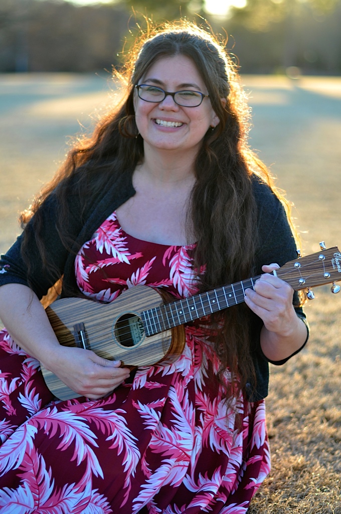 woman smiling and holding a ukelele